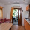 Cucina con tavolo, divano e porta aperta sul giardino.