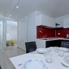 Cucina moderna con tavolo apparecchiato e sedie nere.