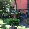 Giardino verde con casa rosa e scala.