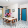 Sala da pranzo con tavolo, cucina e vista mare.