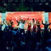 Spettacolo colorato con gruppo di persone che ballano sul palco.
