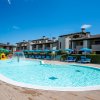 Spiaggia con ombrelloni blu, lettini e mare azzurro sullo sfondo.