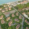 Vista aerea di un villaggio con case e piscina.