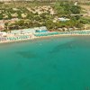Spiaggia con mare turchese e strutture turistiche.