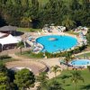 Vista dall'alto di due piscine in un giardino con alberi.