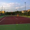 Campo da tennis con persone che giocano.