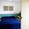 Una camera con letto matrimoniale, coperte blu e opere d'arte sulle pareti.