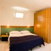 Una camera da letto con letto matrimoniale, armadio in legno e due lampade da parete.