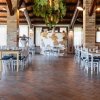 Ristorante interno con tavoli e sedie bianche.