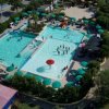 Veduta aerea di piscine con ombrelloni verdi.