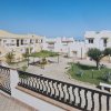 Complesso residenziale mediterraneo con cortile alberato.