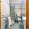 Bagno moderno con doccia ad angolo e piastrelle decorative blu e bianche.
