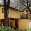 Casa gialla a due piani con balcone.