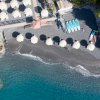 Spiaggia con ombrelloni, kayak e mare blu.