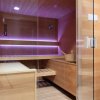 Una sauna in legno con luci soffuse e secchio.