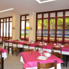 Sala da pranzo con tavoli apparecchiati, tovaglie rosa e finestre ampie.