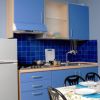 Cucina con mobili blu, piastrelle blu e tavolo apparecchiato.