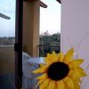 Fiore di girasole con balcone e vista sulla città in lontananza.