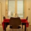 Soggiorno moderno con cucina rossa, tavolo e divano nero.