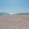 Una spiaggia assolata con ombrelloni e mare calmo.