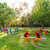 Area giochi con dondoli a molla a forma di cavallo e auto rossa su prato.