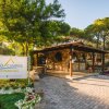 Ingresso del campeggio Arcobaleno con segnaletica e giardino fiorito.