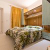 Camera da letto con letto matrimoniale e copriletto tropicale.