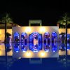 Edificio illuminato con piscina riflettente di notte.