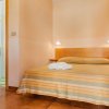 Camera da letto con letto matrimoniale, lenzuola a righe e asciugamani piegati.