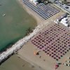 Spiaggia con molti ombrelloni colorati, vista dall'alto. Mare e stabilimenti.