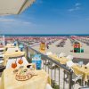 Tavoli all'aperto con bevande su una terrazza vista mare.