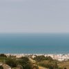 Panoramica su mare e colline verdi.