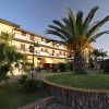 Edificio residenziale con palme e giardino curato.