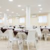 Sala da pranzo con tavoli apparecchiati.