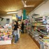 Interno di un negozio con scaffali pieni di prodotti e persone che fanno acquisti.