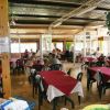 Ristorante con tavoli apparecchiati e sedie di plastica nere.