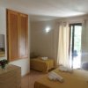 Camera da letto con letti gialli, cassettiera chiara, armadio a muro e accesso al balcone.