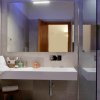 Un bagno con lavabo moderno, ampio specchio e accessori da toilette.