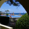 Piscina con vista mare, ombrelloni e piante.