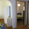 Corridoio di un hotel con letto a righe, armadio e bagno a vista.