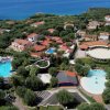 Veduta aerea di un villaggio turistico con piscine e verde.