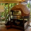 Forno a legna in una cucina con vetrate.