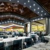 Interno di ristorante elegante con tavoli apparecchiati.