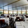 Ristorante con tavoli apparecchiati e sedie marroni.
