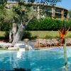 Piscina all'aperto circondata da alberi e vegetazione.