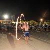 Esibizione di giocoleria col fuoco davanti a un pubblico di notte.