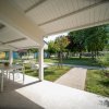 Veranda con tavolo, sdraio e giardino curato.