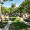 Sentiero tra bungalow e alberi.