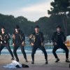 Gruppo di persone balla davanti a una piscina all'aperto.