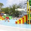 Parco acquatico con giochi d'acqua colorati e scivoli. Persone che si divertono.